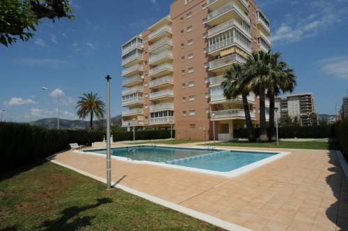 a building with a swimming pool in front of a building at PLAYASOL Orangecosta 1 dormitorio in Benicàssim