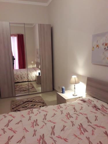 1 dormitorio con cama y espejo grande en CASA DI AGNESE, en Altavilla Milicia