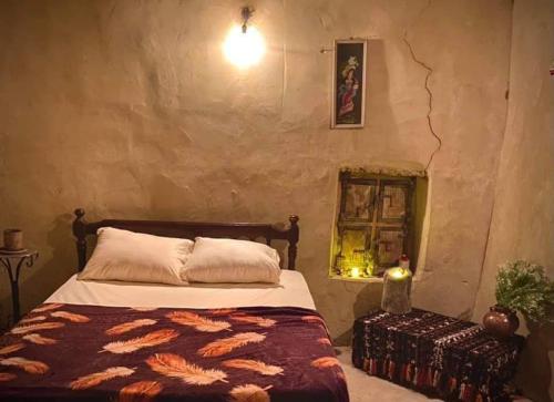 a bedroom with a bed in a stone wall at NaInshal Siwa in Siwa