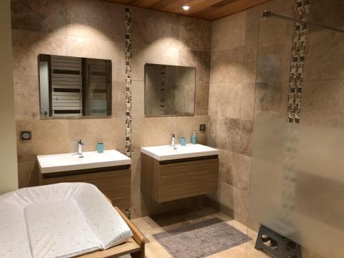 a bathroom with two sinks and a shower at La Grenaderie in Sergeac