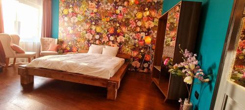 a bedroom with a bed and a floral wall at Paradiso Perduto Private Apartment by Weinkeller in Sibiu
