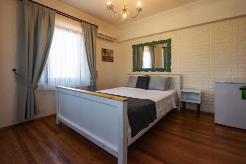 a bedroom with a large bed and a window at Ebruli Hotel in Bozcaada