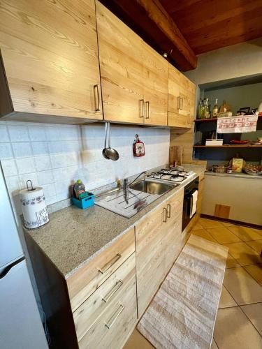 a kitchen with wooden cabinets and a sink and a stove at Appartamento la Torre Vinadio in Vinadio
