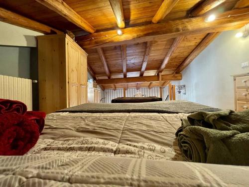 un grande letto in una camera con soffitti in legno di Appartamento la Torre Vinadio a Vinadio