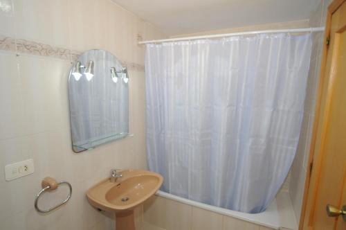 uma casa de banho com um lavatório e um chuveiro com um espelho. em MADEIRA Orangecosta 1 dormitorio em Benicàssim