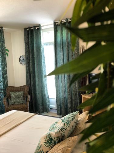 a bedroom with green curtains and a bed and a chair at Equateur-centre Jaude in Clermont-Ferrand
