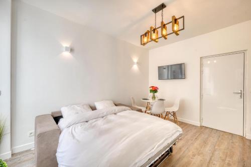 a white bedroom with a bed and a table at HR Rambuteau - Châtelet in Paris