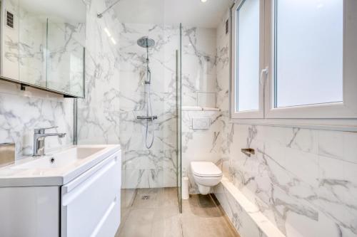 une salle de bain blanche avec des toilettes et un lavabo dans l'établissement HR Rambuteau - Châtelet, à Paris