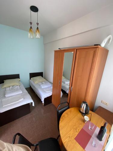 a room with two beds and a table and a mirror at Villa Jakos Paradise in Batumi