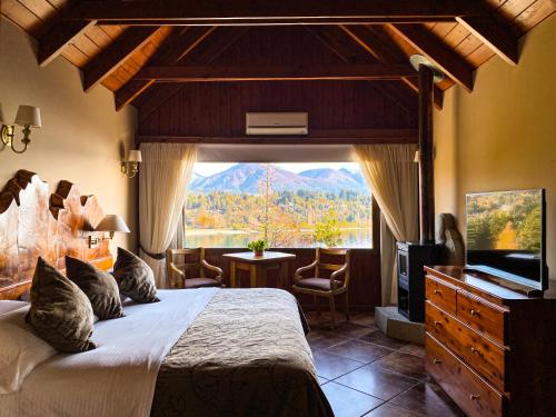 a bedroom with a large bed and a large window at Charming Luxury Lodge & Private Spa in San Carlos de Bariloche