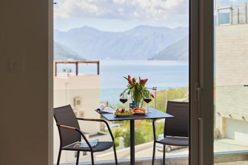 a table and chairs on a balcony with a view of the water at Defne's House View in Kotor