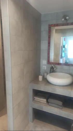 une salle de bain avec un lavabo et un miroir dans l'établissement Studio chaleureux vue sur le massif du vercors ., à Alixan