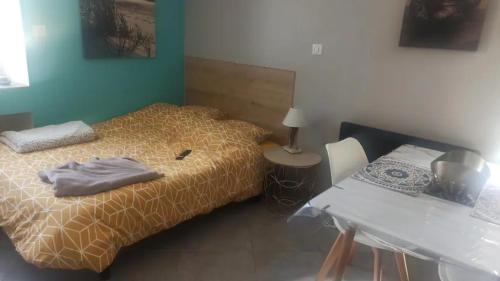 Schlafzimmer mit einem Bett, einem Tisch, einem Tisch und einem Bett in der Unterkunft Studio chaleureux vue sur le massif du vercors . in Alixan