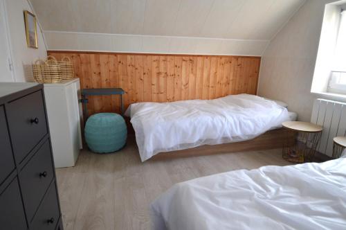 a bedroom with two beds and a wooden wall at Appt cosy - 300m plage-proche Arromanches et Bayeux in Asnelles