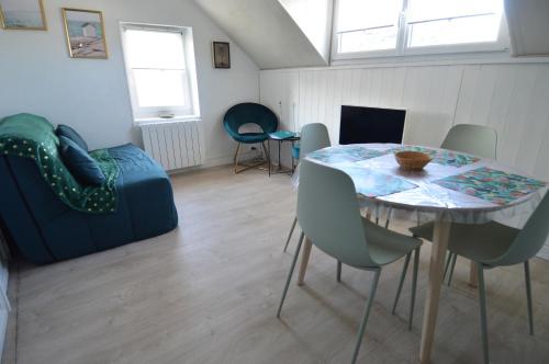 a living room with a table and chairs and a couch at Appt cosy - 300m plage-proche Arromanches et Bayeux in Asnelles