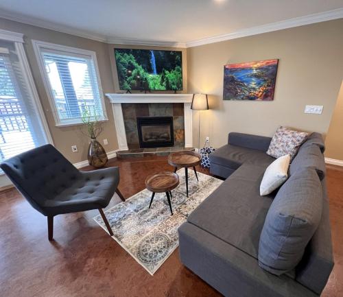 a living room with a couch and a fireplace at Lovely J Home -Stunning river view cozy two bedroom private suite in New Westminster