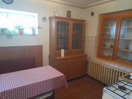 a kitchen with a table and a cabinet and a window at Dorina in Gyenesdiás