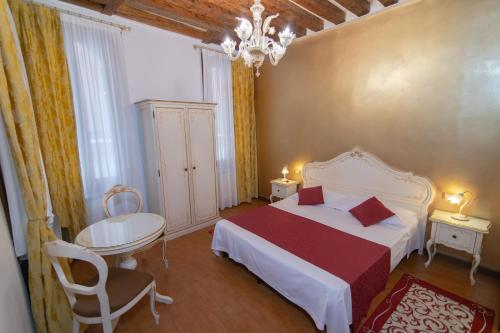 um quarto com uma cama, uma mesa e uma cadeira em Ca Del Sole Venice em Veneza