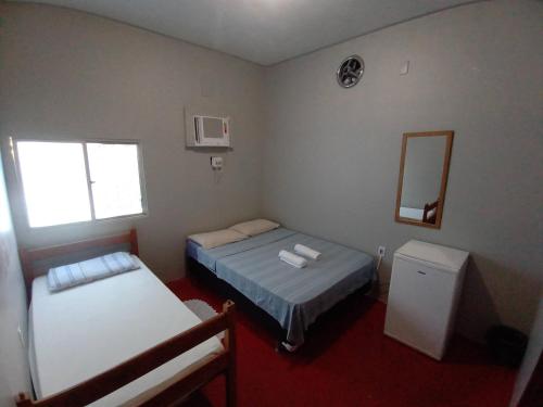 a small room with two beds and a mirror at Discovery hostel in Manaus