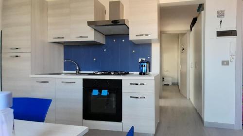 a kitchen with white cabinets and a black stove top oven at Jak's Home Laigueglia in Laigueglia