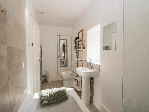 a white bathroom with a sink and a toilet at No 2 Waterloo Street in Cockermouth