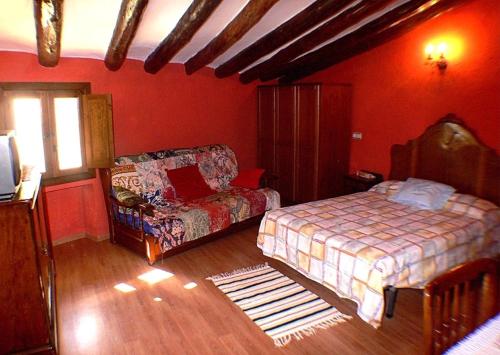 um quarto com uma cama e um sofá num quarto em Casa Lino Huesca em Chibluco