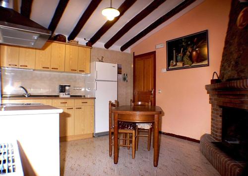 una pequeña cocina con mesa y nevera en Casa Lino Huesca, en Chibluco