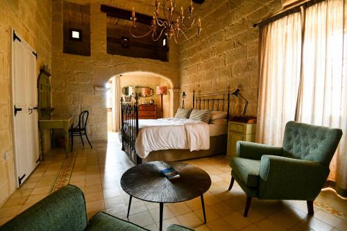 a bedroom with a bed and two chairs and a table at Maria's B&B in Għasri