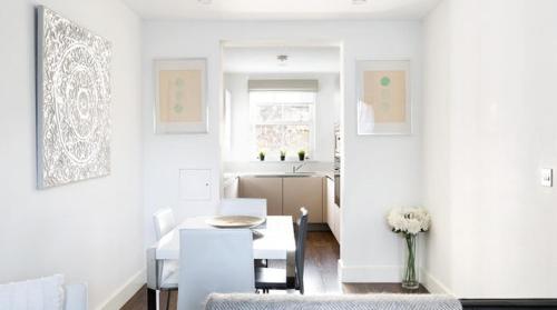 a white living room with a table and a kitchen at Tower Bridge Lux-Townhouse in London