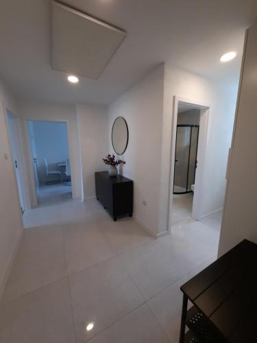 a white living room with a mirror and a dresser at apartmán Filloména in Liptovský Mikuláš
