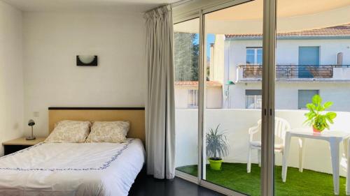 1 dormitorio con 1 cama y balcón en Superbe appart avec de parking gratuit sur place, en Lourdes