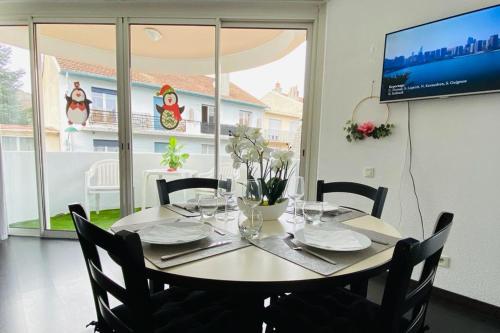 a dining room table with chairs and a tv at Superbe appart avec de parking gratuit sur place in Lourdes