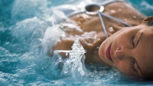 a person laying in the water in a swimming pool at Azcapri Villa Boutique & Spa in Cancún
