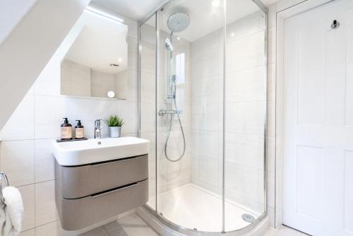 ein weißes Bad mit einer Dusche und einem Waschbecken in der Unterkunft Be London - The Soho Residences in London