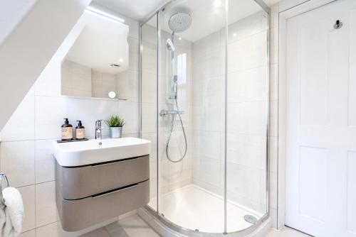 Un baño blanco con ducha y lavabo. en Be London - The Soho Residences, en Londres