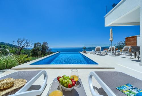 Villa con piscina y mesa con fruta en Villa Bellevue Bast en Baška Voda