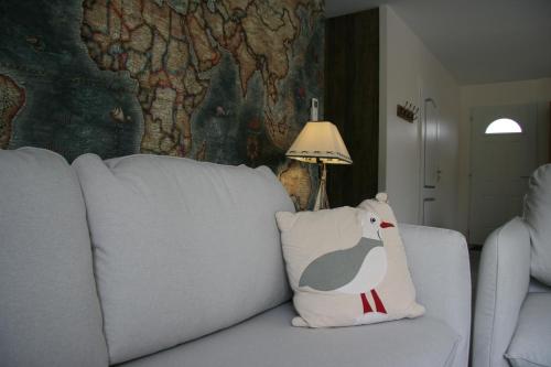 a white couch with a chicken pillow on it at Le Domaine de Louise in Seigy