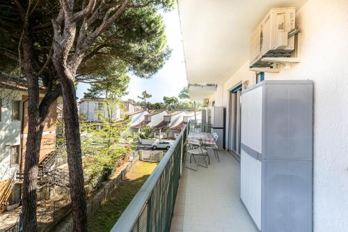 an apartment patio with a tree and a fence at Casa Vacanze Spina in Lido di Spina