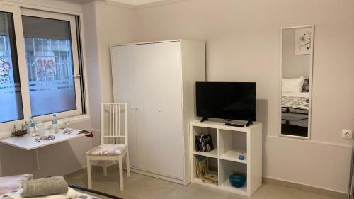 una sala de estar con TV en un armario blanco en Chris AKROPOLI, en Atenas