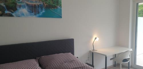 ein Schlafzimmer mit einem Bett und einem Tisch mit einer Lampe in der Unterkunft Gartenappartement Leonsberg in Bad Ischl