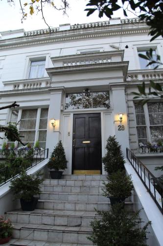 a white house with a black door and stairs at Dawson Place, Juliette's Bed and Breakfast in London