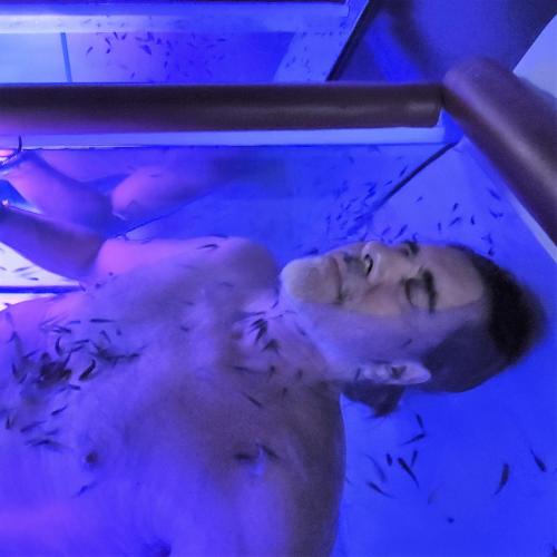 a man in a swimming pool in a blue light at Azcapri Villa Boutique & Spa in Cancún