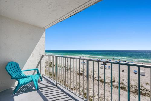 a blue chair on a balcony overlooking the beach at The Reef At Seahaven Beach Resorts in Panama City Beach