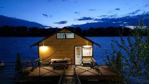 una cabaña en un muelle en un lago por la noche en Apartman na vodi, en Belgrado