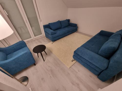 a living room with two blue couches and a table at Uvac lake "FF" in Sjenica