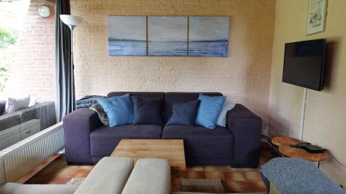 a living room with a purple couch and a table at Oude-Tonge holiday house near fishing waters in Oude-Tonge