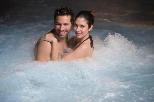 a man and a woman in a hot tub at Azcapri Villa Boutique & Spa in Cancún