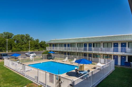 an aerial view of a building with a pool and umbrellas at Motel 6-Bellmead, TX - Waco in Bellmead