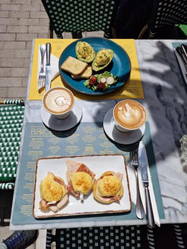 a table with two plates of food and two cups of coffee at Concierge Monastiraki in Athens