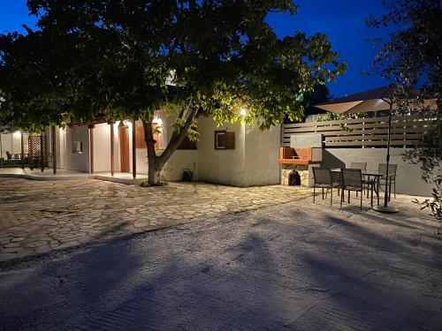 a patio with a table and chairs under a tree at V-Suites in Potos